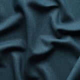 Close-up van donkerblauwe kamerverduisterende gordijnen, getextureerd met lichte plooien, met lichtblokkerende stof.