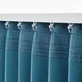 Teal kamerverduisterende gordijnen hangen aan een witte roede met haken, die het licht blokkeren en privacy bieden.