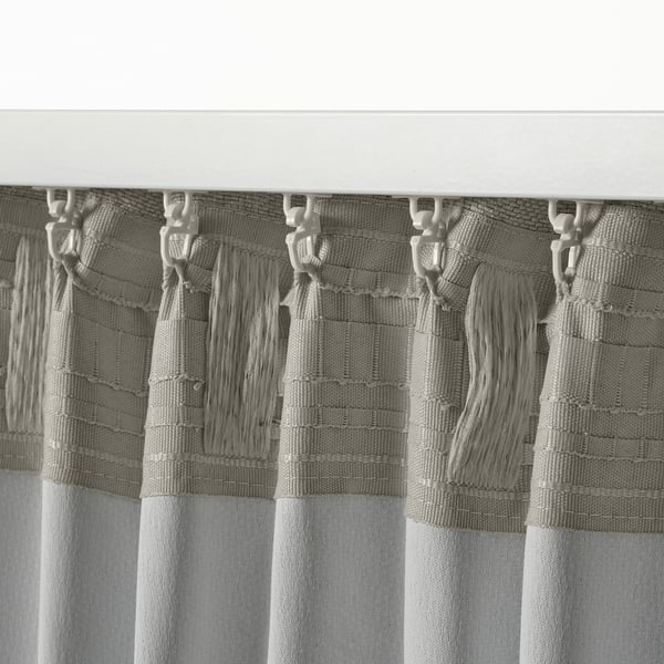 Zwart-witte close-up van gordijnen, met haken en kwasten. Gordijnen ontworpen met kopband voor gemakkelijk plooien en een formeel tintje.