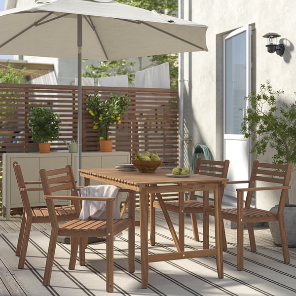 Acacia hout buiten eetset met kussens stoelen & parasol, perfect voor kleine patio's. Inclusief fruitschaal, omgeven door planten.
