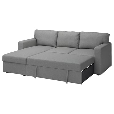 Een grijze BÅRSLÖV slaapbank met een chaise longue. Het heeft zachte vormen en grote kussens, perfect om te ontspannen.