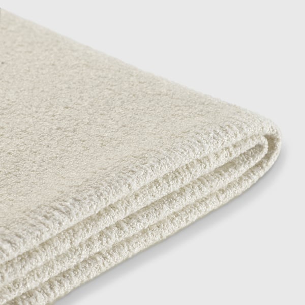 Gevouwen witte badhanddoek, zacht en pluche, waarschijnlijk gemaakt van gerecyclede materialen.