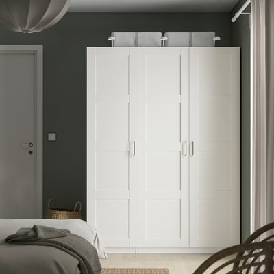 Witte BERGSBO kledingkast in de slaapkamer, hoog, 4 vierkante deuren, donkergroen wandcontrast.