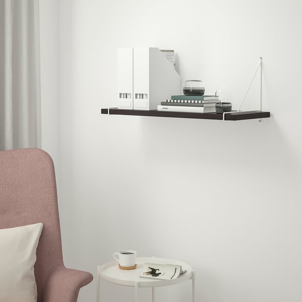Moderne zwarte plank BERGSHULT op witte muur, kleiner dan stoel, met decor.