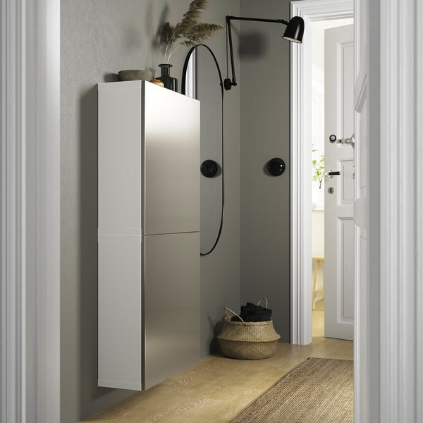 Moderne grijze BESTÅ kast met push-open deuren, grote mand en wandlamp in de hal; lang, strak en minimalistisch.