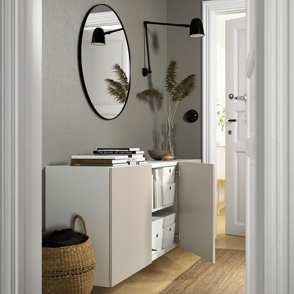 Minimalistische entree: aan de muur gemonteerde opbergkast met open deuren, spiegel, verlichting en decoratie.