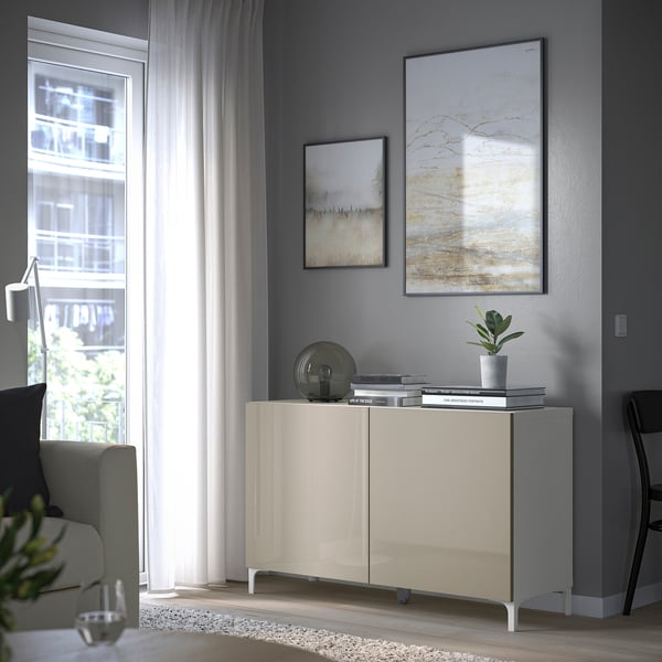 Moderne woonkamer met BESTÅ opbergmeubel, boeken, planten en kunst.