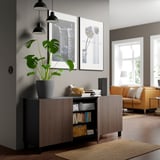 Moderne woonkamer met BESTÅ dressoir, planten en oranje banken.