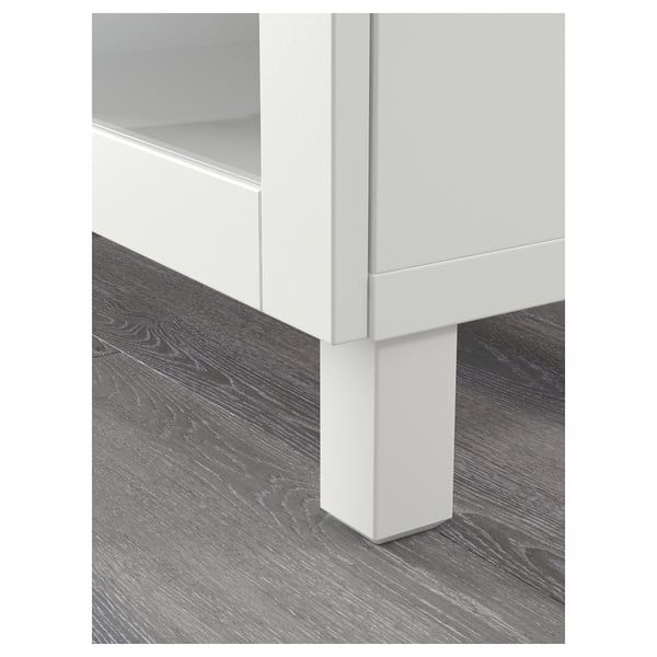 Moderne witte kast met strak design, verstelbare planken en donkere houten vloer, met meubels van hoge kwaliteit.