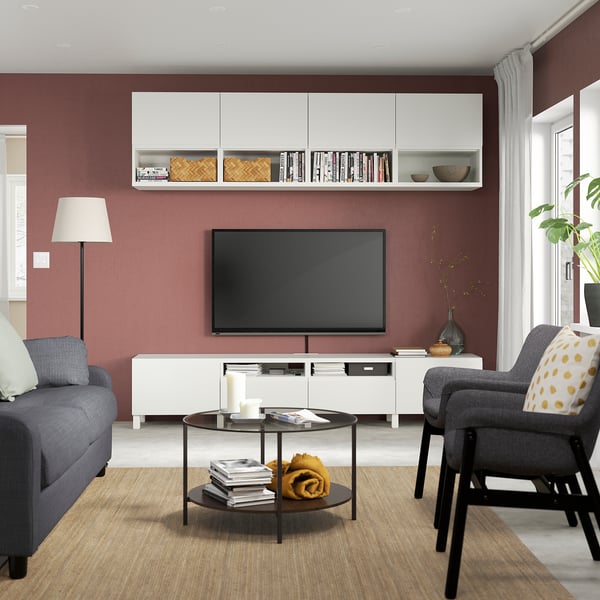 Moderne woonkamer met rode muren, grijze bank, tv-meubel en inrichting.