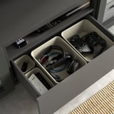 Open medialade met technische accessoires: controllers, koptelefoons, afstandsbedieningen, kabels.