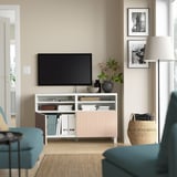 Woonkamer met groenblauwe bank, flatscreen-tv op wit BESTÅ tv-meubel met open opbergruimte en planten.