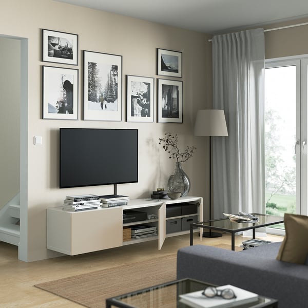 Moderne woonkamer met BESTÅ tv-meubel, planken, kabelbeheer en luchtig design. Flatscreen-tv, foto's, grijze gordijnen.