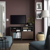 Moderne woonkamer met verstelbare opberg-tv-standaard, met een flatscreen-tv en versierd met vazen en ingelijste foto's.