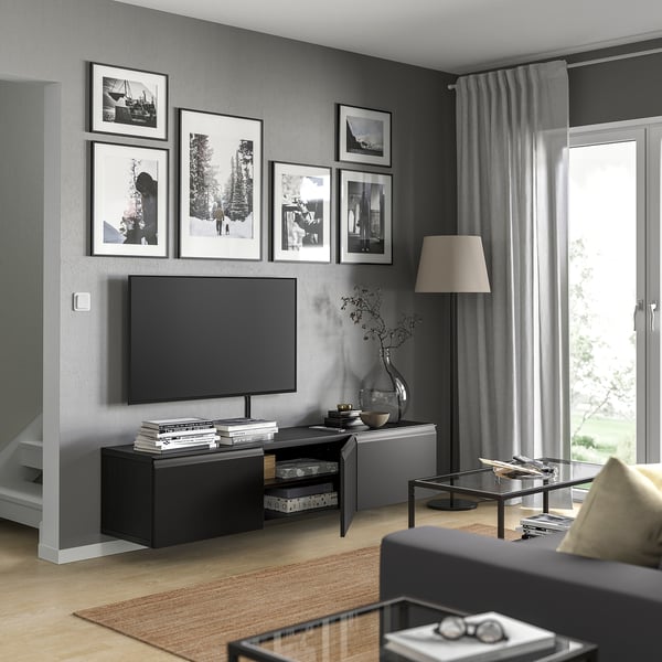 Moderne woonkamer met zwart BESTÅ tv-meubel met een flatscreen-tv, boeken en een glazen salontafel.