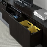 Donkerhouten tv-standaard met open lade met geel interieur en gamecontroller. Inclusief verstelbare planken en kabelbeheer.