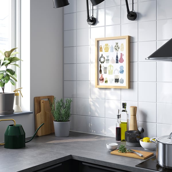 Moderne keuken met grote poster van kleurrijke vazen achter toonbank, planten en keukengereedschap.