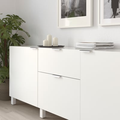 Witte kast met BILLSBRO handgrepen, display maandmappen, drie kaarsen bovenop.