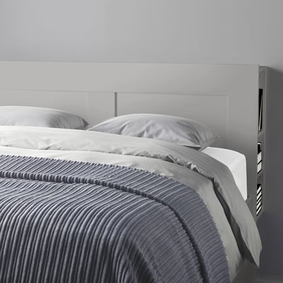 Modern bed met hoofdeinde met verborgen opbergplanken, optimaal voor kleine ruimtes.