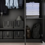 Goed georganiseerde kledingkast met hangende overhemden, opgevouwen kleding, planken en tassen. Inclusief spiegeldeur en verstelbare planken.