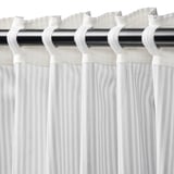 Gestreepte gordijnen met kopband op zwarte roede, geplooid voor privacy en diffuus licht.