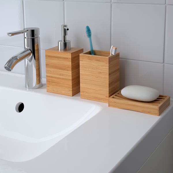 Moderne wastafel in de badkamer met chromen kraan, houten zeepdispenser, tandenborstelhouder en zeepbakje. Bamboe houten accessoires zorgen voor een warme, natuurlijke uitstraling.