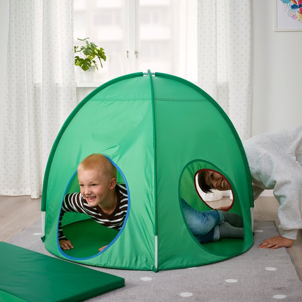 Twee kinderen spelen in een groene pop-up tent en genieten van hun privéruimte met ronde ramen.