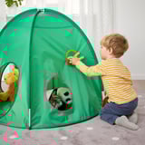 Het spelen van het kind met groene pop-up tent. De jongen in gestreept overhemd opent tentflap en onthult opgezette dieren binnenin.