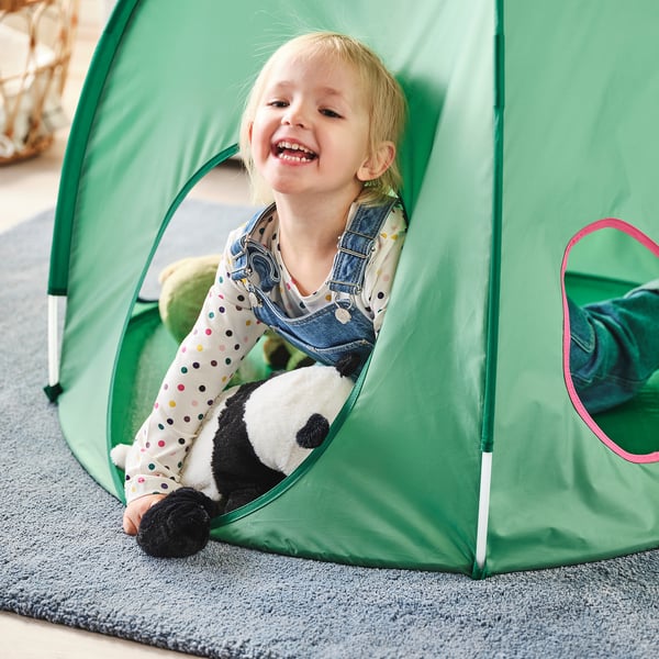 Gelukkig kind spelen in groene DVÄRGMÅS tent met gevulde panda.