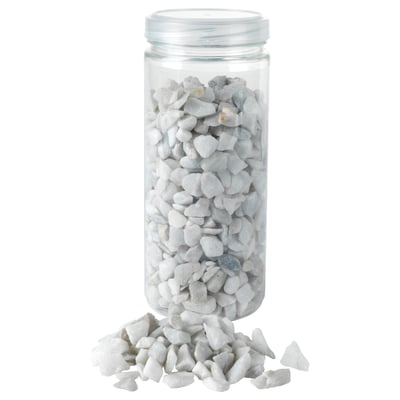 Pot met witte stenen, sommige gemorst.