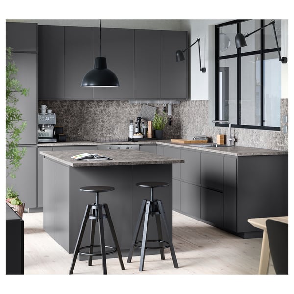 Moderne keuken met EKBACKEN grijs werkblad en bijpassende kasten, verstelbare barkrukken, hanglamp en glazen raam.