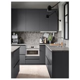 Moderne keuken met donkergrijs aanrecht en achterwand, ingebouwde oven, gootsteen, koffiezetapparaat, zwarte verlichting, lichte houten vloer.