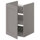 Deze afbeelding toont een grijze ENHET badkamerkast met één deur open, waardoor planken binnenin zichtbaar worden. De kast is rechthoekig met gladde oppervlakken.