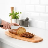 Snijden van meergranenbrood op houten plank.