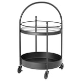 Zwart metalen badkamertrolley met glazen bovenblad en diepe bodemplaat, op wielen met handvat.