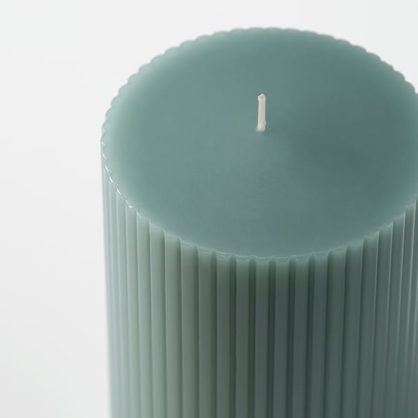 Elegante, groenachtig blauwe kaars met verticale groeven, onverlichte lont gecentreerd aan de bovenkant, kwaliteit duidelijk in ontwerp en afwerking.