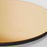 Ronde goudkleurige tafelmat op wit oppervlak. Gladde, metalen randen, geluiddempend.
