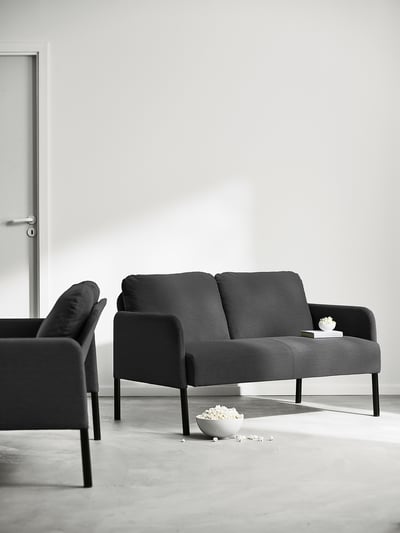 Zwarte GLOSTAD loveseat. Compact, stijlvol met gedempte zittingen en armleuningen, ondersteund door slanke metalen poten.