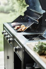 Zilveren grill die buiten kookt met gegrild fruit.