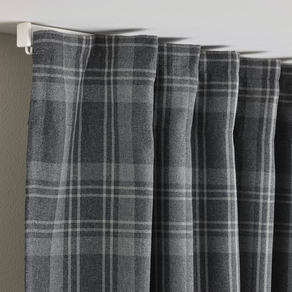 Donkergrijze gordijnen met tartan patroon hangend, met kamerverduisterende stof en privacyfunctie.