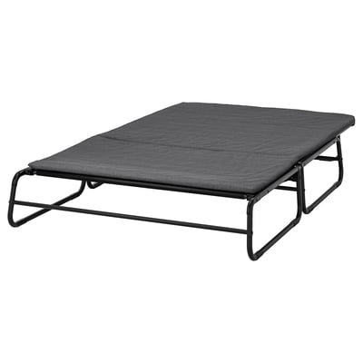 Zwarte slaapbank met metalen frame, zitting met kussens en rugleuning.