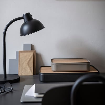 Zwart bureau met onder andere een doos met kurken kurk.