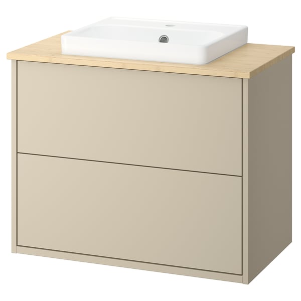 Een beige HAVBÄCK badkamerkast met een bamboe aanrecht en een wit keramisch wastafel. De kast heeft lades en een modern ontwerp.