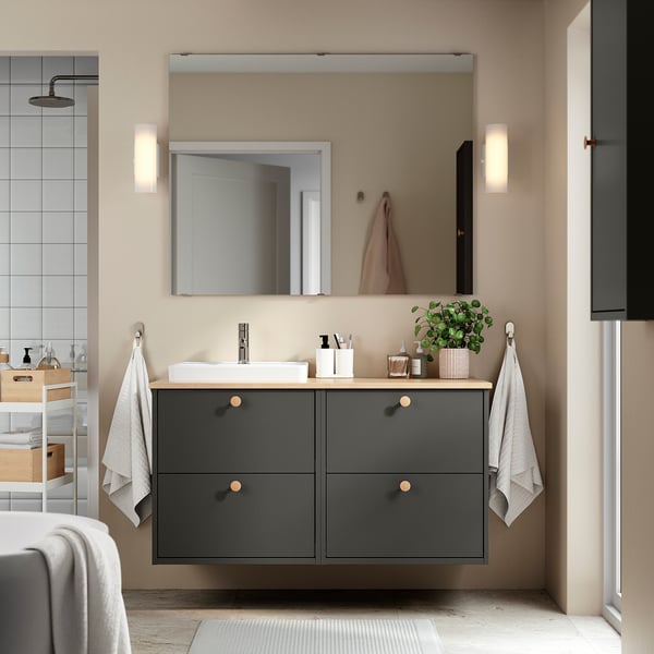 Moderne badkamer met donkergrijze HAVBÄCK wastafel, wastafel, grote spiegel, wandverlichting en handdoeken.