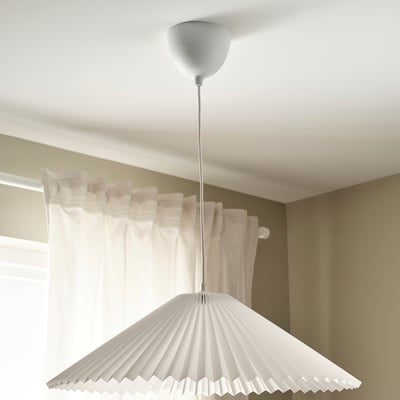 Aan een plafondsnoer hangt een witte geplooide lampenkap die een kamer verlicht.