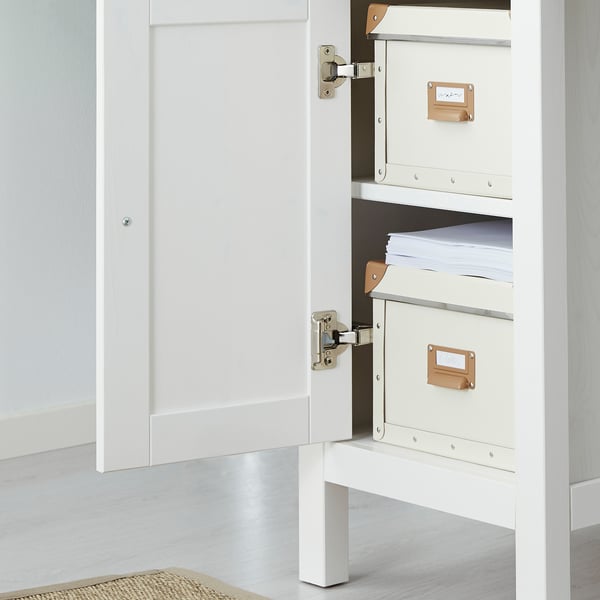 Open witte houten kast met drie crèmekleurige mappen, waarvan één met papieren op de middelste plank.