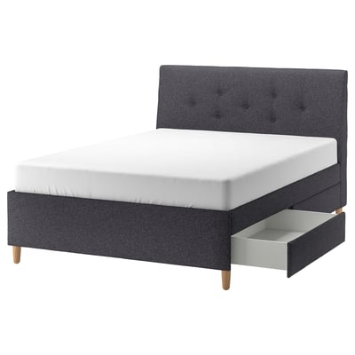 Modern grijs gestoffeerd bed met schuin hoofdeinde, houten poten en opberglades voor compacte ruimtes, IDANÄS-serie.
