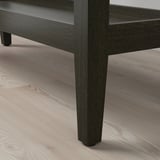 Donkerhouten wandtafel met strakke, schuine poten staat op een lichte houten vloer. Ambachtelijk gemaakt van beukenfineer, voor een verfijnde en stoere uitstraling.