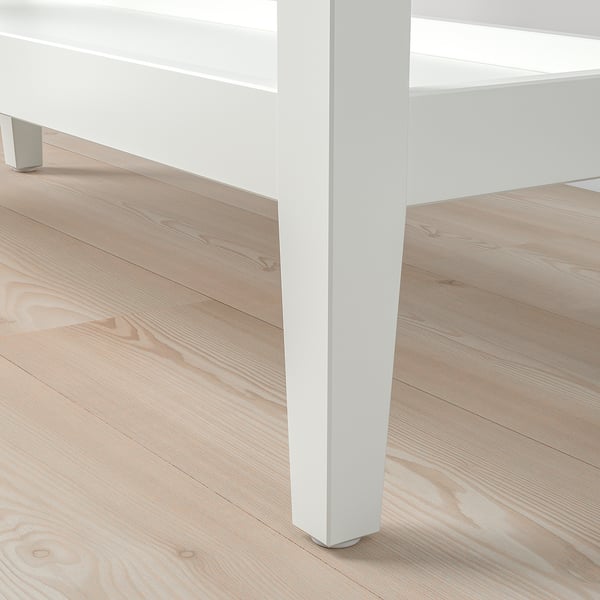 Close-up van een slanke, witte consoletafelpoot, met strakke lijnen en een gladde afwerking.