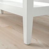 Close-up van een slanke, witte consoletafelpoot, met strakke lijnen en een gladde afwerking.